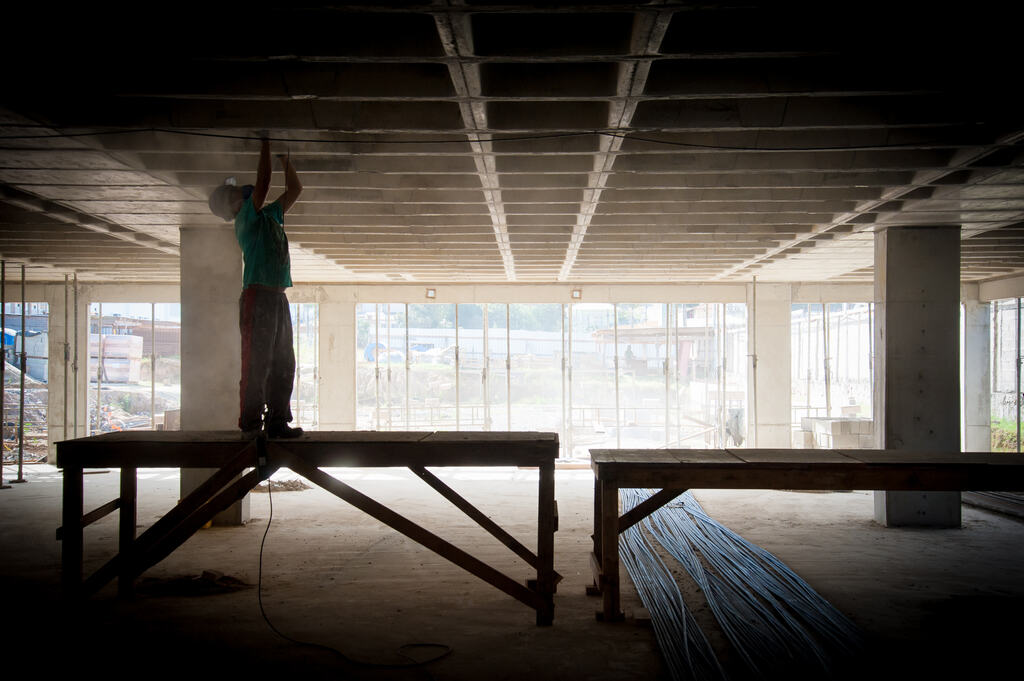 Operário em obra, valores de materiais e serviços relacionados na tabela SINAPI